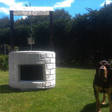 Pozo como caseta de perro. Caseta de perro con forma de pozo, y pequeño estanque en la parte superior.